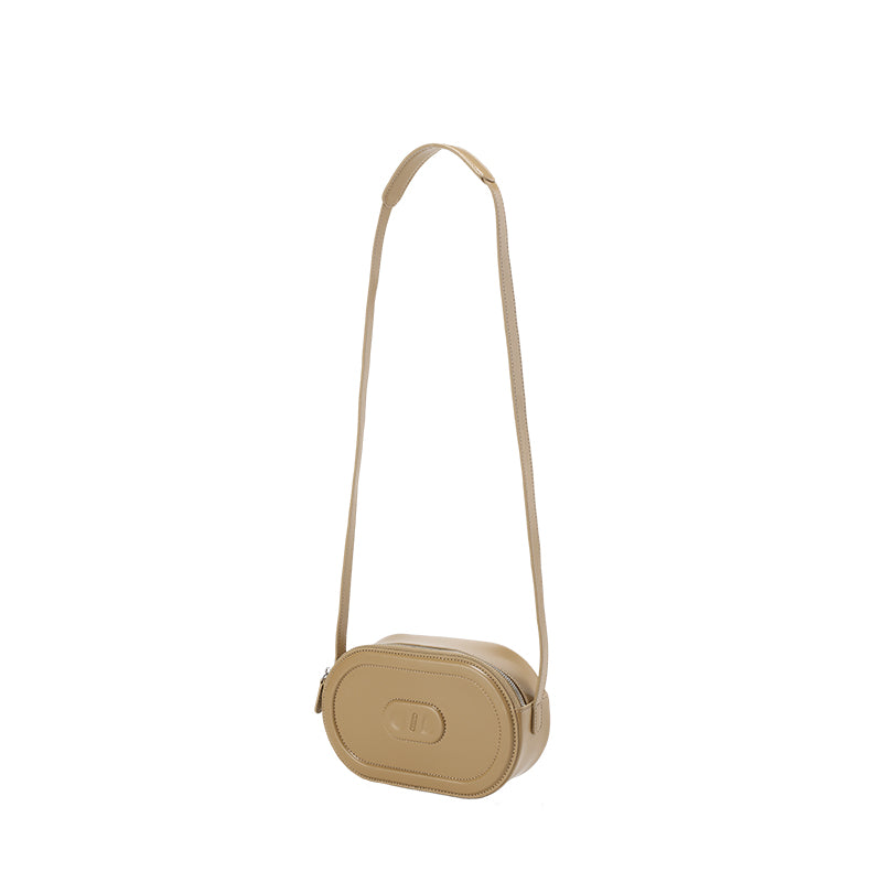 RSNY Oval Loop Pig Nose Shoulder Bag - Milk Tea Color - RSNY Length 20.5 * Width 6 * Height 12cm Shoulder strap 110cm net size Round, cow leather, quilted, front concave embossed logo, top zipper, main interlayer, shoulder.
